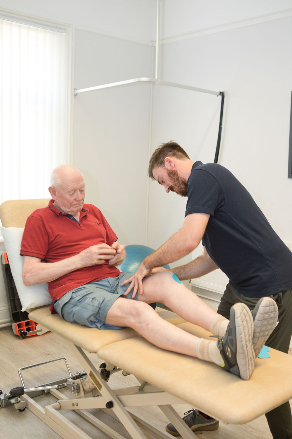 Sports therapist assessing a patient's knee at the SoCo Therapies clinic