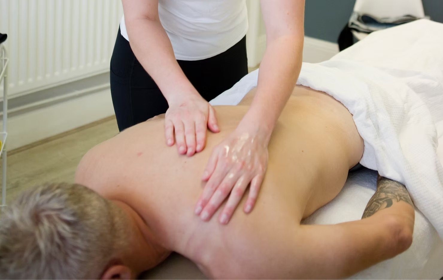 Osteopath providing hands-on treatment to a patient lying face down