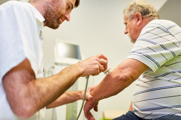 Person experiencing pain in their elbow while sitting at home